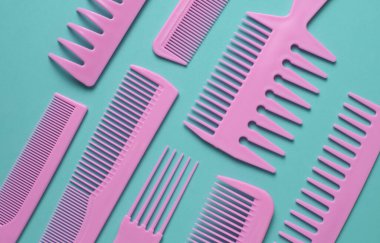 Nane yeşili arkaplanda pembe plastik taraklar.