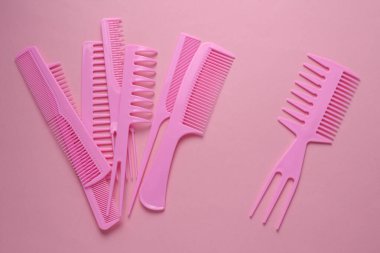 Pembe arkaplanda plastik taraklar.