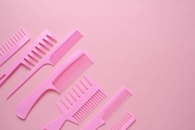 Pembe arkaplanda plastik taraklar.