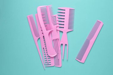 Nane yeşili arkaplanda pembe plastik taraklar.