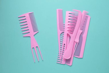 Nane yeşili arkaplanda pembe plastik taraklar.