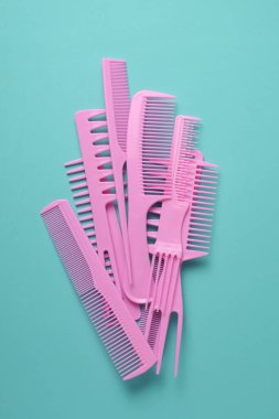 Nane yeşili arkaplanda pembe plastik taraklar.