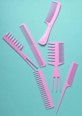 Nane yeşili arkaplanda pembe plastik taraklar.