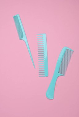 Pembe arkaplanda mavi plastik taraklar.