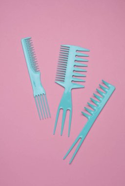 Pembe arkaplanda mavi plastik taraklar.