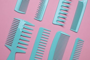 Pembe arkaplanda mavi plastik taraklar.