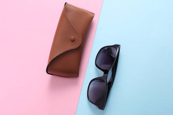 Кожаный чехол с солнцезащитными очками на розовом фоне