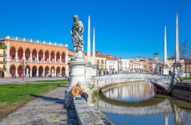 Padua, İtalya - 21 Mart 2013: Prato Della Valle insanlarla rahatlatıcı kare kanal boyunca heykeller