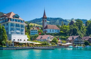 Hilterfingen, İsviçre - 10 Temmuz 2015: Thun lakeside parish Kilisesi ile ülkenin görünüm