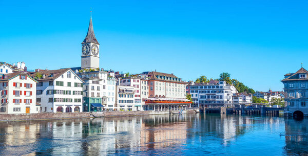 Zurich, Switzerland - July 10, 2016: View of the city center on the Limmat river with the St. Peter bell tower in the background
