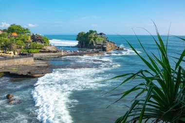 Bali, Endonezya - 24 Şubat 2017: Denizde Tanah Lot tapınağın kutsal mağara ile küçük ada