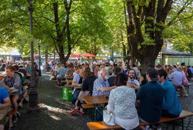 Münih. Almanya - 27 Temmuz 2018: Victualien gıda pazarında oturan yerli halk ve turistler