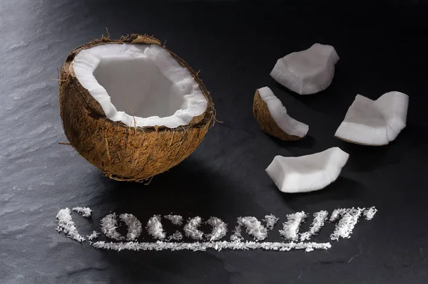 Half Ripe Coconut Its Small Parts Close Black Textural Background — Stock Photo, Image