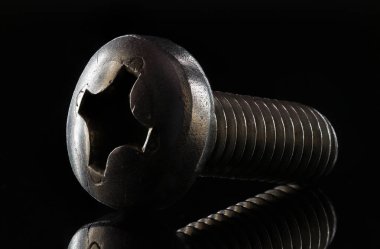 Belirgin doku ve siyah bir arka plan yansıması ile metal vida yakın çekim