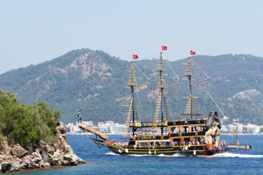 Ormanile büyümüş dağların arka planda Tekne.