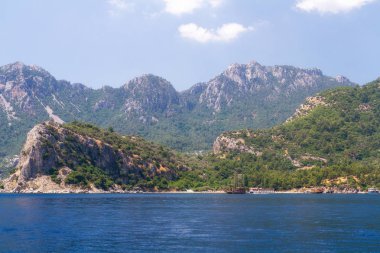 Ege Adaları'nın manzara manzarası. Denizin eşsiz tonları ve çam ağaçlarıyla kaplı kayalar. 