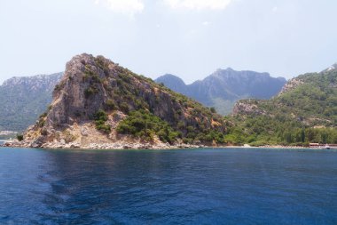 Ege Adaları'nın manzara manzarası. Denizin eşsiz tonları ve çam ağaçlarıyla kaplı kayalar. 