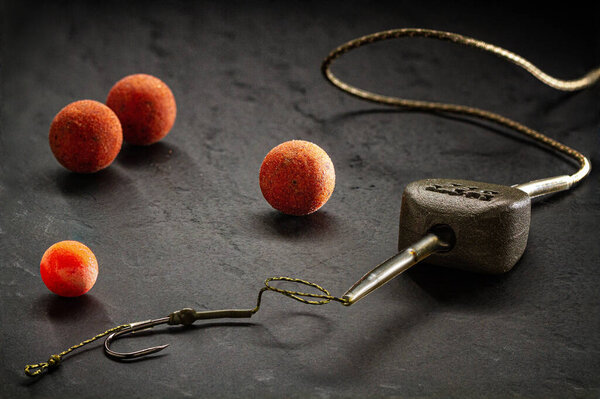 Boil rig for carp fishing with in-line load and boilies on a dark textured background