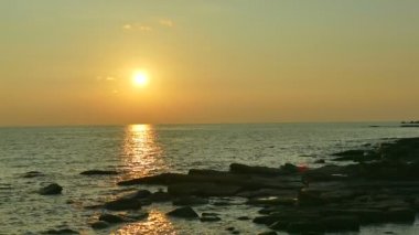 dalgalar deniz, kumsal ve dramatik gökyüzü günbatımı görünümünü