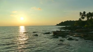 dalgalar deniz, kumsal ve dramatik gökyüzü günbatımı görünümünü