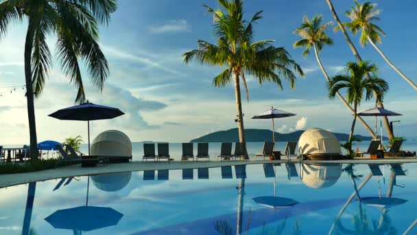 vue sur piscine, parasols et végétation tropicale luxuriante  