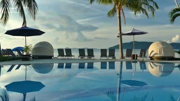 vue sur piscine, parasols et végétation tropicale luxuriante  