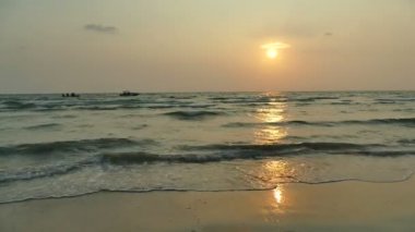 dalgalar deniz, kumsal ve dramatik gökyüzü günbatımı görünümünü