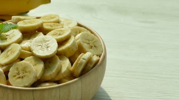 Φέτες Μπανάνες Ξύλινο Μπολ Και Μπανάνες Ολόκληρο Στο Τραπέζι — Αρχείο Βίντεο
