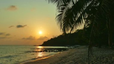 dalgalar deniz, kumsal ve dramatik gökyüzü günbatımı görünümünü