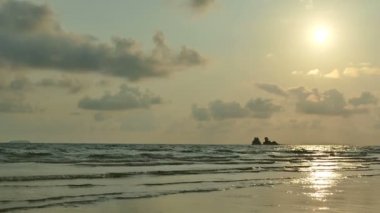 dalgalar deniz, kumsal ve dramatik gökyüzü günbatımı görünümünü