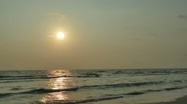 dalgalar deniz, kumsal ve dramatik gökyüzü günbatımı görünümünü