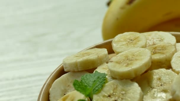 Gesneden Bananen Houten Kom Hele Bananen Tafel — Stockvideo