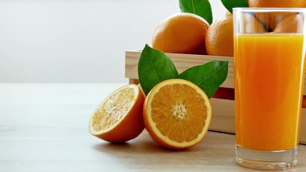 Sterta Świeżych Pomarańczy Drewnianym Pudełku Szklanka Soku — Wideo stockowe