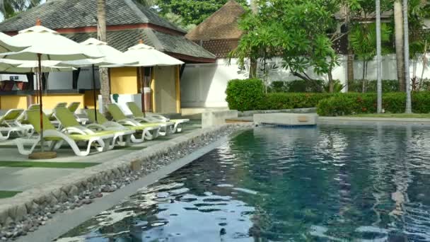 vue sur piscine, parasols et végétation tropicale luxuriante  