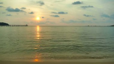 dalgalar deniz, kumsal ve dramatik gökyüzü günbatımı görünümünü