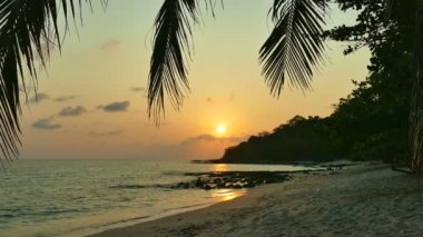 dalgalar deniz, kumsal ve dramatik gökyüzü günbatımı görünümünü