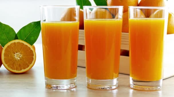 木の箱やジュースのグラスに新鮮なオレンジの山 — ストック動画