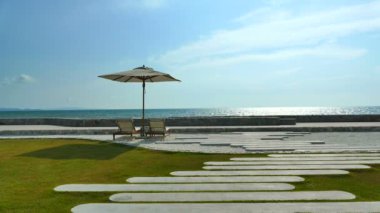 deniz dalgalarıyla pitoresk Marina, sahilde güneş şemsiyesi ve mavi gökyüzü