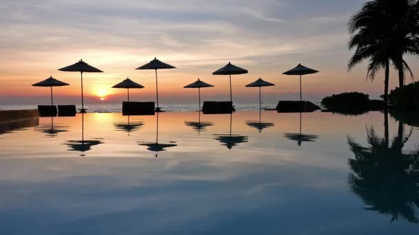 parasols et coucher de soleil sur la mer et la piscine