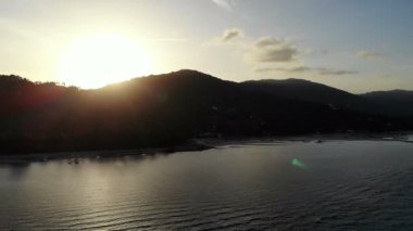 deniz, palmiye ağaçları ve dramatik günbatımı gökyüzü inanılmaz görünümünü