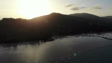 deniz, palmiye ağaçları ve dramatik günbatımı gökyüzü inanılmaz görünümünü