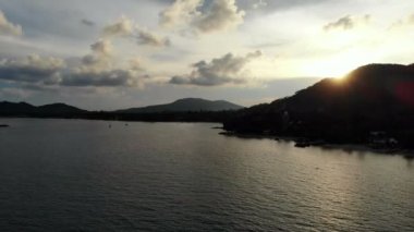 deniz, palmiye ağaçları ve dramatik günbatımı gökyüzü inanılmaz görünümünü