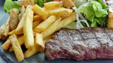 Lezzetli ızgara biftek, sebze ve patates kızartması.