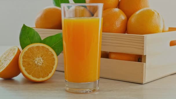 Stapel Frischer Orangen Holzkiste Und Glas Saft — Stockvideo