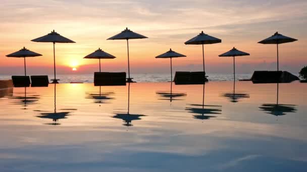 太陽の傘と海とプールの夕日 — ストック動画