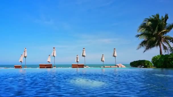 Solparasoller Och Utsikt Över Havet Och Poolen — Stockvideo