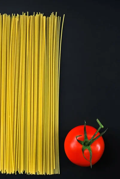 黒を基調としたスパゲティと赤トマト — ストック写真