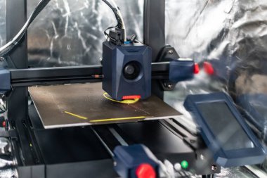 3D yazıcı, tepsiye iplik, mısır nişastası ve su geçirmez iplik içeren bir nesne basıyor.