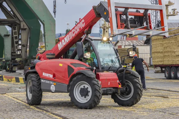 Varna, Bulgaristan Eylül, 19, 2016; Manitou Maniscopic dört tekerlekli sürücü forklift traktör saman balya bir römork üzerine yükleme 
