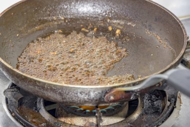 bir tavada gaz şeker caramelizing mutfak sobası